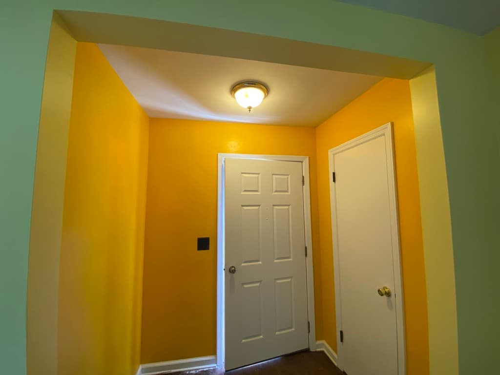 Interior painting with vibrant yellow accent walls and crisp white trim